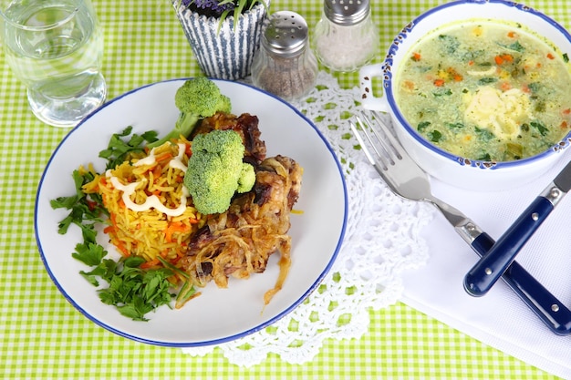 Soupe et riz avec de la viande dans des assiettes sur une serviette sur une nappe