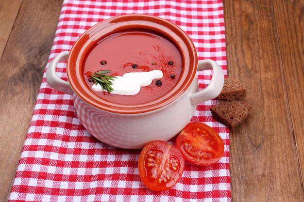 Soupe savoureuse aux tomates sur table en bois