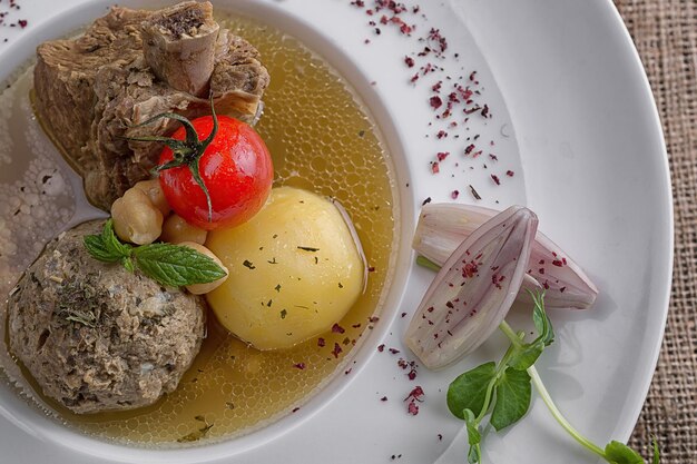 Photo soupe shurpa à l'agneau sur une assiette sur toile de jute