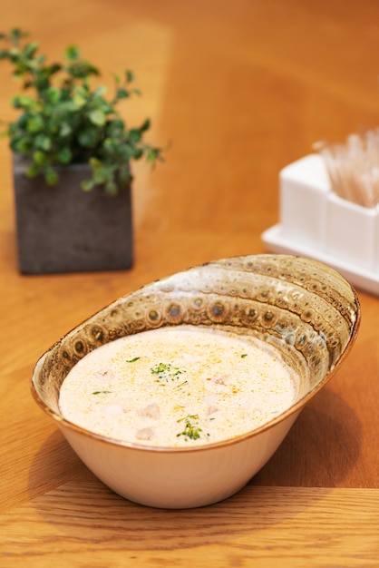 Soupe Tom Kha Gai fraîche au lait de coco avec du brocoli de poulet et des herbes dans un restaurant de cuisine thaïlandaise