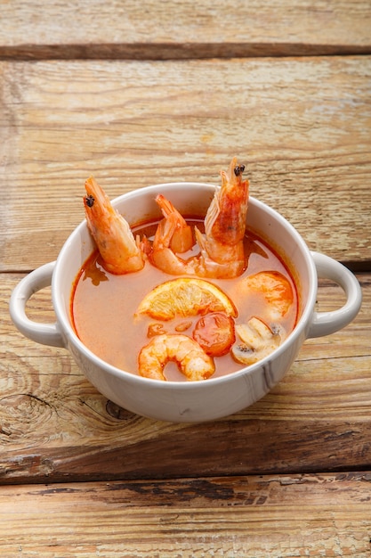 Soupe de tom yam aux crevettes et lait de coco dans une soupière. Photo verticale