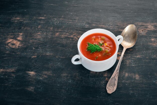 Soupe de tomates au piment et légumes Alimentation saine Sur un fond en bois noir Vue de dessus Copier l'espace pour votre texte
