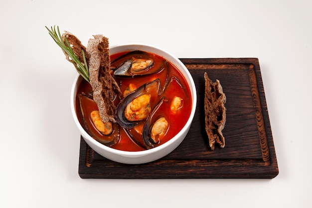 Soupe de tomates aux moules accompagnées de croûtons de seigle garnis de romarin