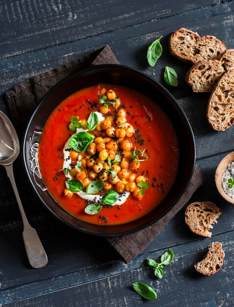 Soupe de tomates aux pois chiches frits épicés sur une vue de dessus de table en bois foncé Concept de cuisine végétarienne