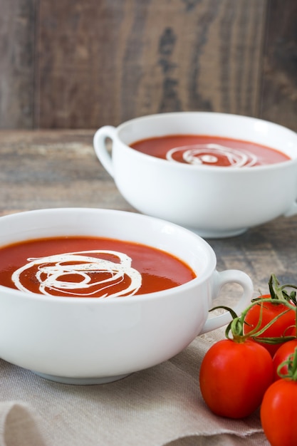 soupe de tomates fraîches dans un bol blanc sur table en bois