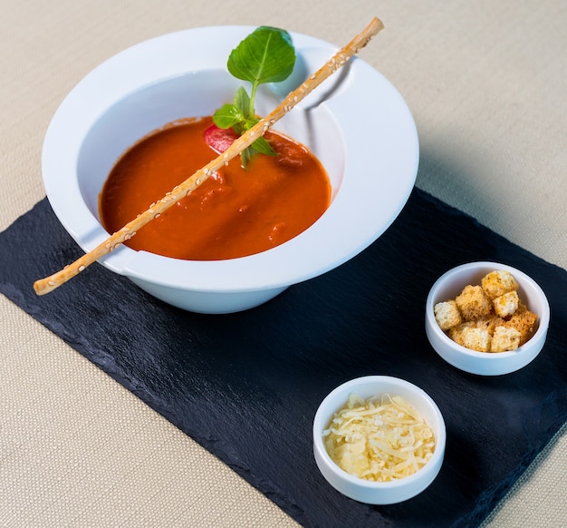 Soupe de tomates rouges avec chapelure sur la plaque noire