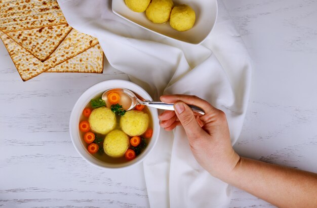 Soupe traditionnelle de balle de matsa, plat juif de Pâque, servi avec de la matsa, une Haggadah de Pâque