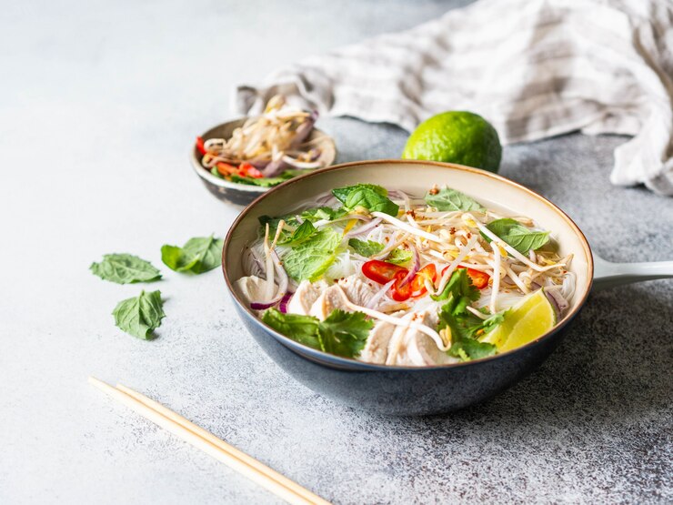 Soupe traditionnelle vietnamienne - pho ga dans un bol avec poulet et nouilles de riz