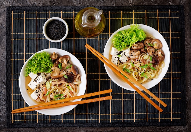 Soupe Végétalienne Aux Nouilles Avec Tofu, Champignons Shiitake Et Laitue Dans Un Bol Blanc.