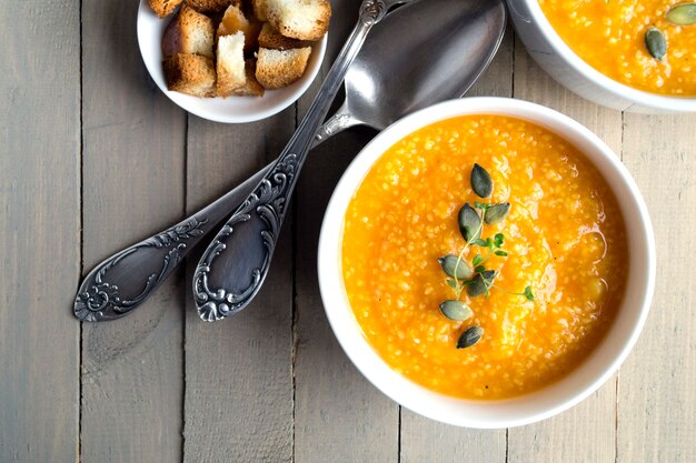 Photo soupe végétarienne à la citrouille sur une table en bois.