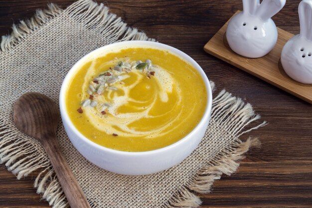 Soupe végétarienne à la citrouille sur une table en bois.