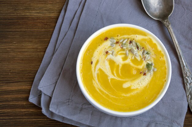 Soupe végétarienne à la citrouille sur une table en bois.