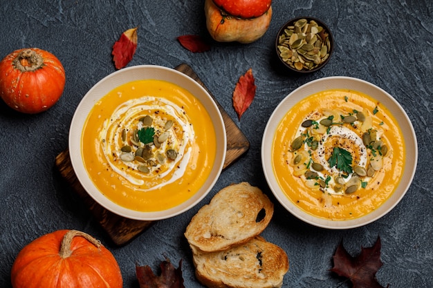 Soupe végétarienne à la crème de citrouille d'automne avec des graines dans des bols blancs. Soupe à la citrouille