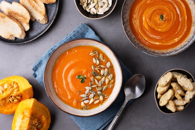 Soupe végétarienne à la crème de citrouille sur fond gris.