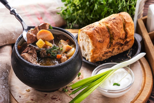 Soupe de viande aux champignons et légumes. Soupe de viande dans une casserole avec du pain croustillant