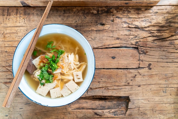 Soupe vietnamienne aux nouilles de riz avec porc et poulet sur table en bois