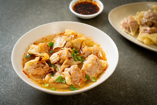 soupe wonton de porc ou soupe de boulettes de porc avec chili rôti - style cuisine asiatique