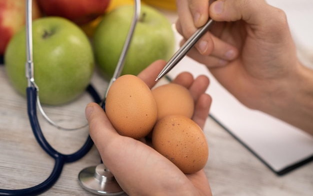 Sources naturelles d'acide folique vitamine b9 aliments comme oeufs d'avocat foie de brocoli orange haricots asperges épinards noix et graines sur table en bois