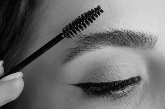 Photo les sourcils en gros plan avec un pinceau pour sourcils en gros plan les sourcils les sourcills la lamination des sourcils les procédures de sourcils longs cils les sour cils macro