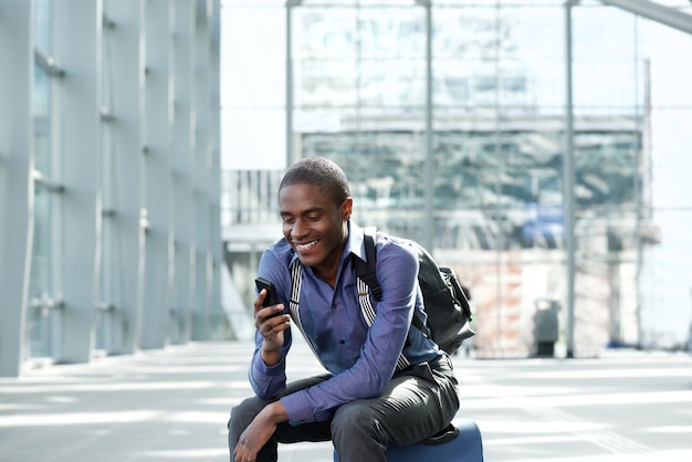 souriant afro-américain homme d&#39;affaires en attente à la gare