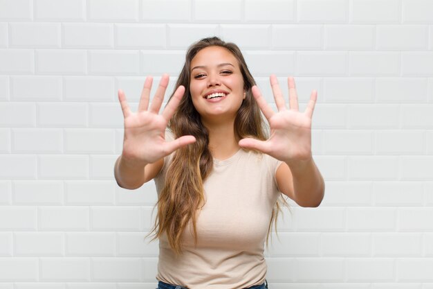 souriant et à l'air amical, montrant le numéro dix ou dixième avec la main vers l'avant, compte à rebours