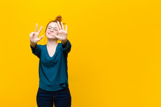 souriant et à l'air amical, montrant le numéro huit ou huit avec la main en avant, compte à rebours