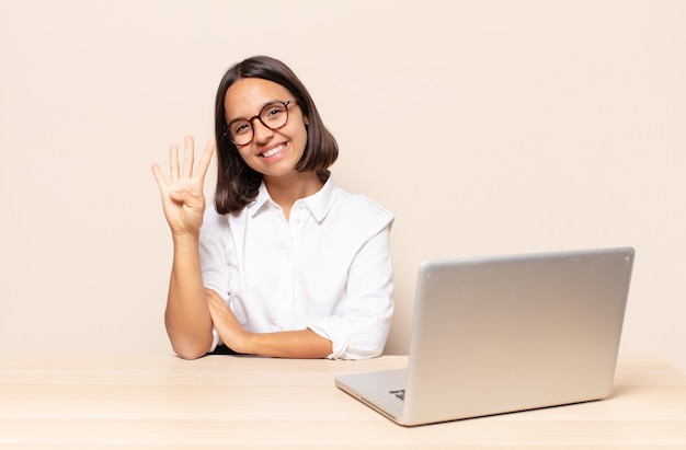 Souriant et l'air amical, montrant le numéro quatre ou quatrième avec la main en avant, compte à rebours