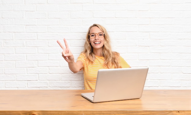 souriant et l'air heureux, insouciant et positif, gesticulant la victoire d'une main