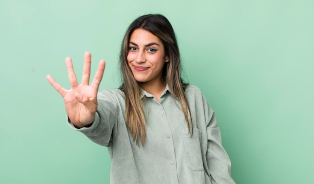 Souriant et amical montrant le numéro quatre ou quatrième avec le compte à rebours de la main vers l'avant