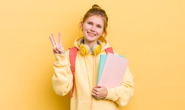 Souriant et amical montrant le numéro trois