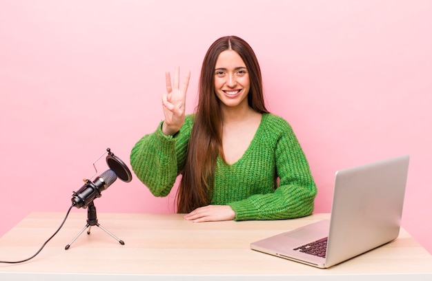 Souriant et amical montrant le numéro trois