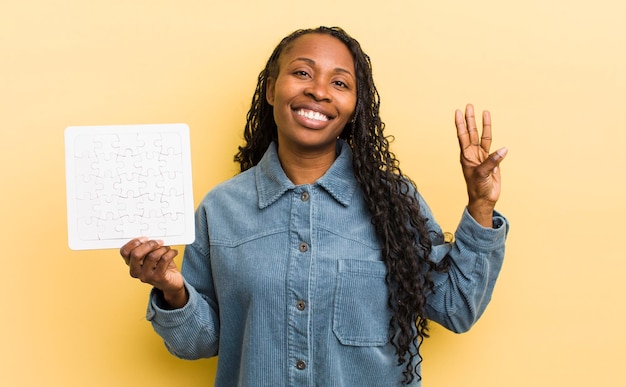 Souriant et amical montrant le numéro trois