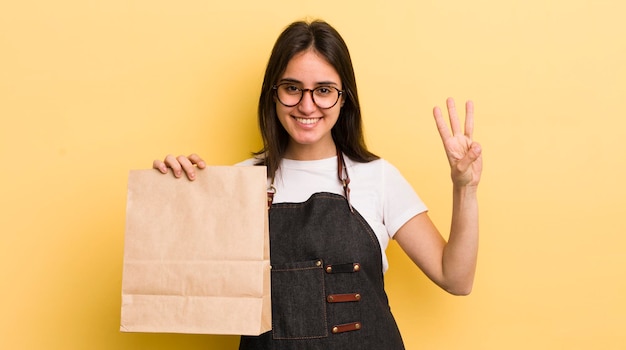 Souriant et amical montrant le numéro trois