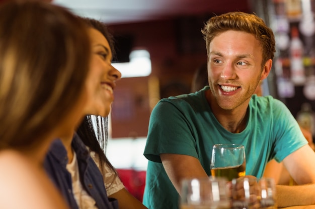 Souriant amis parler et boire de la bière