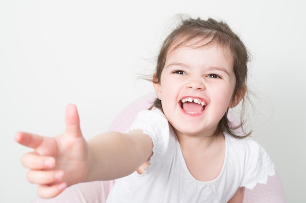 Souriant amusant petit enfant heureux sur fond clair, gros plan