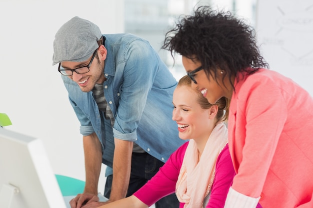 Souriant artistes travaillant sur ordinateur au bureau