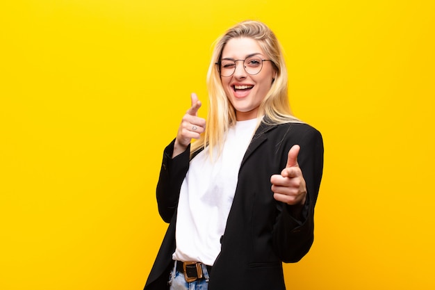 souriant avec une attitude positive, réussie et heureuse pointant, faisant signe de pistolet avec les mains