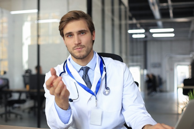 Photo souriant beau médecin de sexe masculin parlant à la caméra avec le patient.