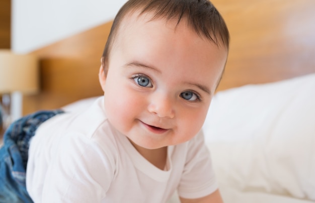 Souriant bébé garçon au lit