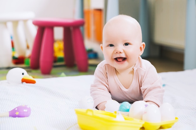 Souriant bébé le plus mignon jouant avec des jouets colorés Heureux bébé de 6 mois jouant et découverte