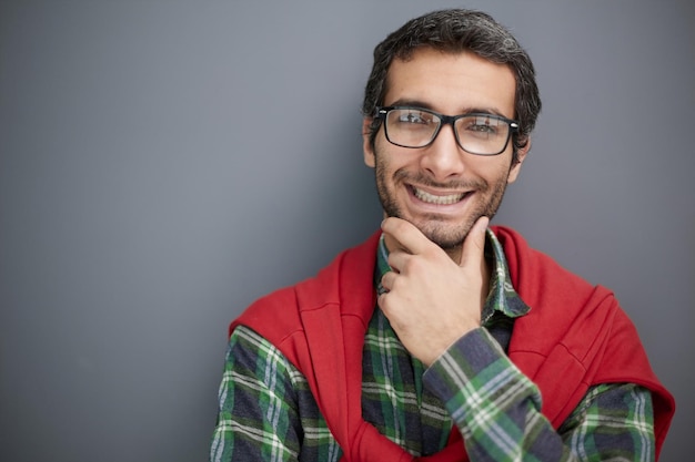 Souriant bel homme en chemise debout avec les bras croisés sur fond gris