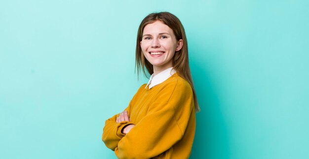 Souriant à la caméra avec les bras croisés et une expression latérale heureuse