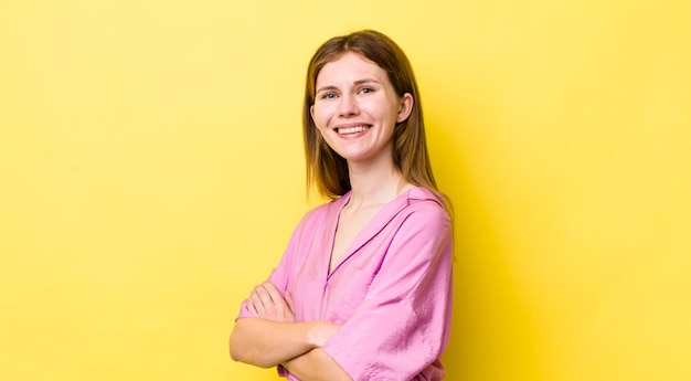 Souriant à la caméra avec les bras croisés et une expression latérale heureuse