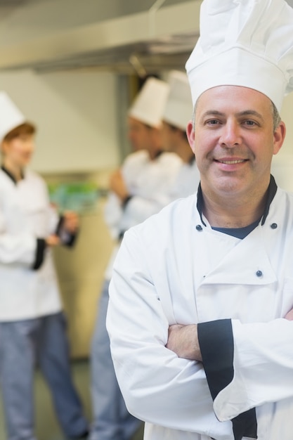 Souriant chef mature posant dans une cuisine