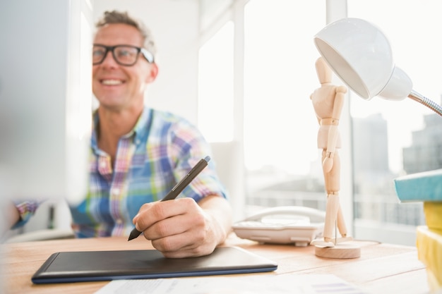 Souriant concepteur occasionnel à l&#39;aide d&#39;ordinateur et numériseur