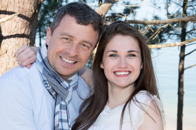 Souriant couple d'amoureux se détendre au bord de la mer l'été