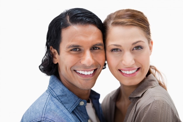 Souriant couple debout près d&#39;un fond blanc