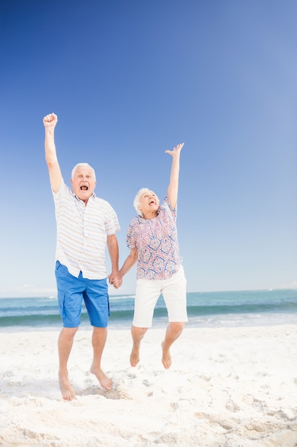 Souriant couple de personnes âgées sautant