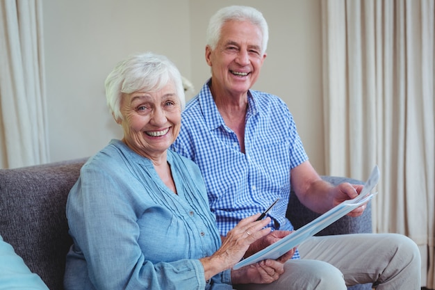 Souriant couple senior avec factures