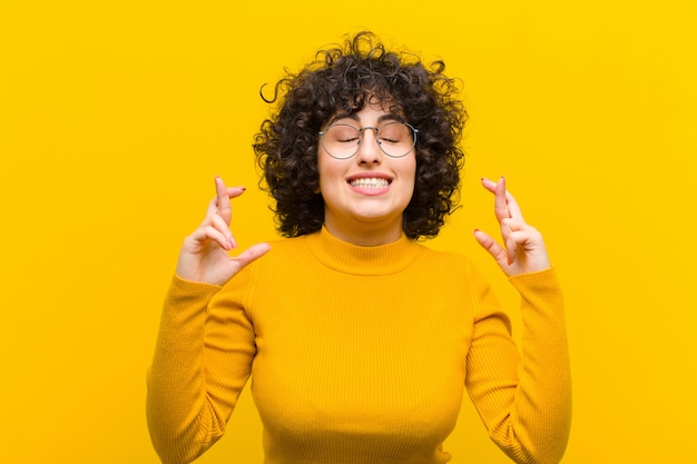 souriant et croisant anxieusement les deux doigts, se sentant inquiet et souhaitant ou espérant bonne chance